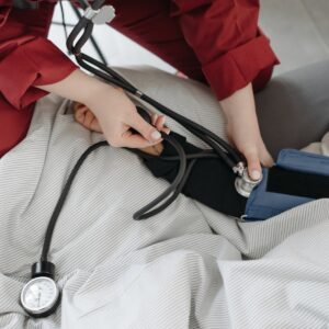 A medical professional checking a patient's blood pressure using a sphygmomanometer in a cozy setting.